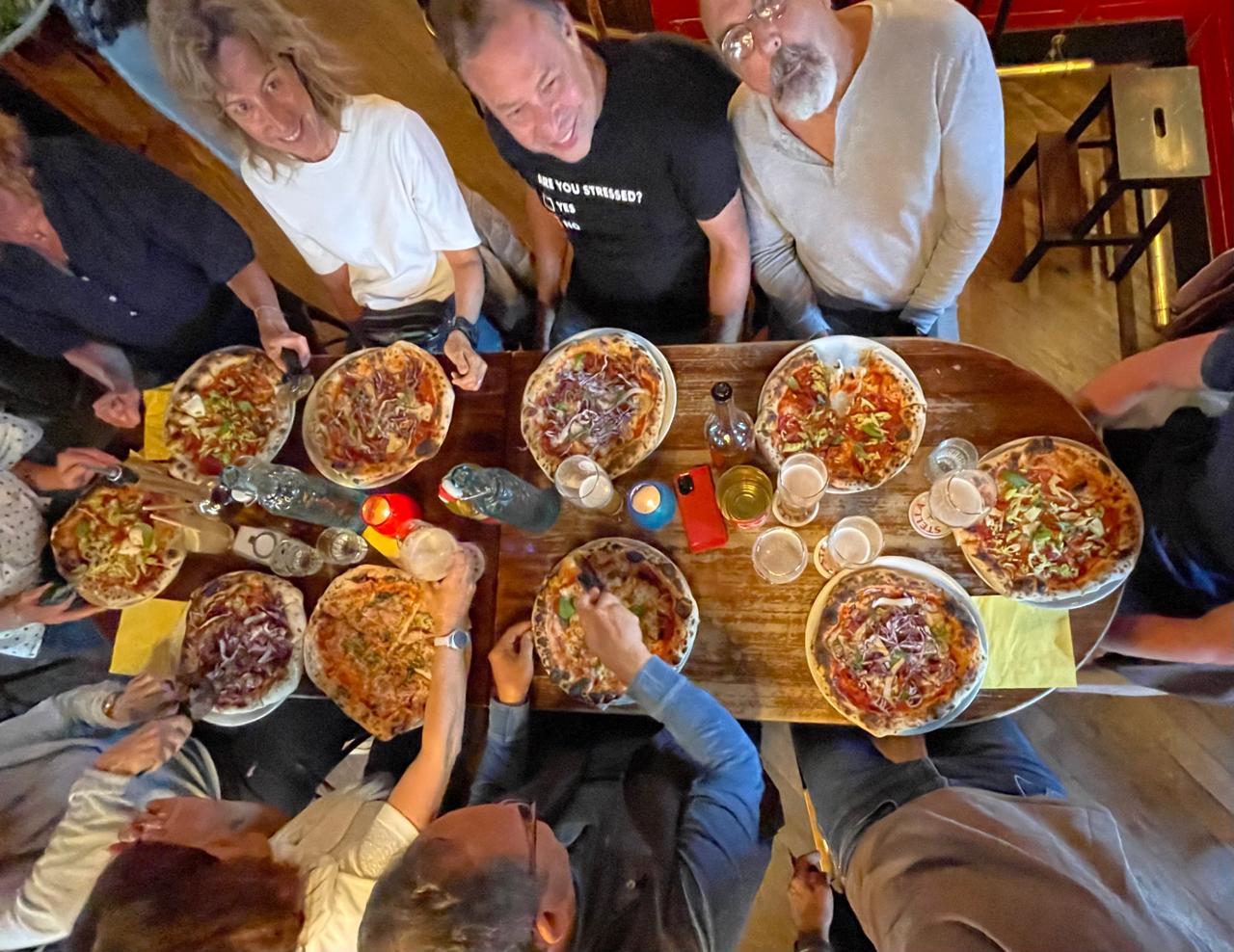 Vue d'en haut : pizzas, bougie, iPhone rouge.